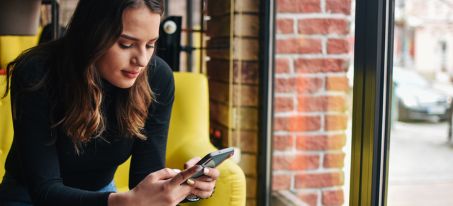 woman on phone looking at her online banking